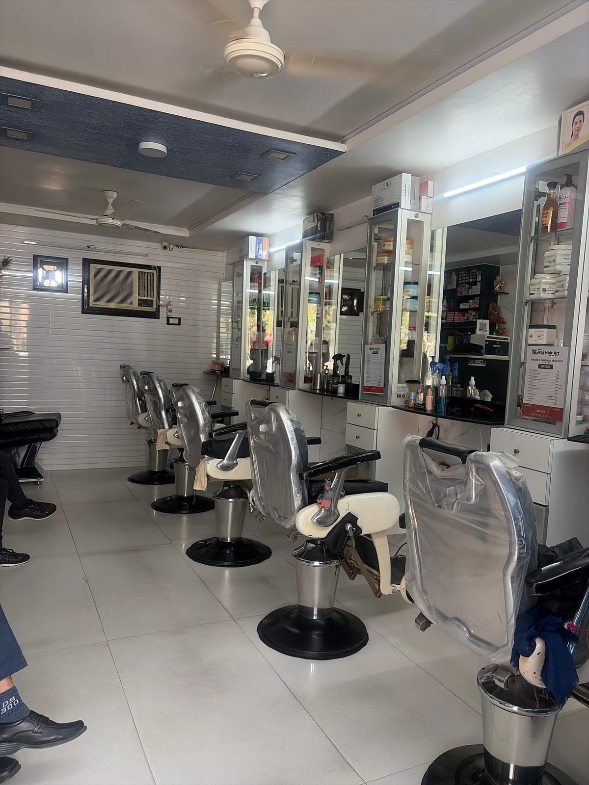 Barbershop interior with rows of chairs facing mirrors and storage cabinets
