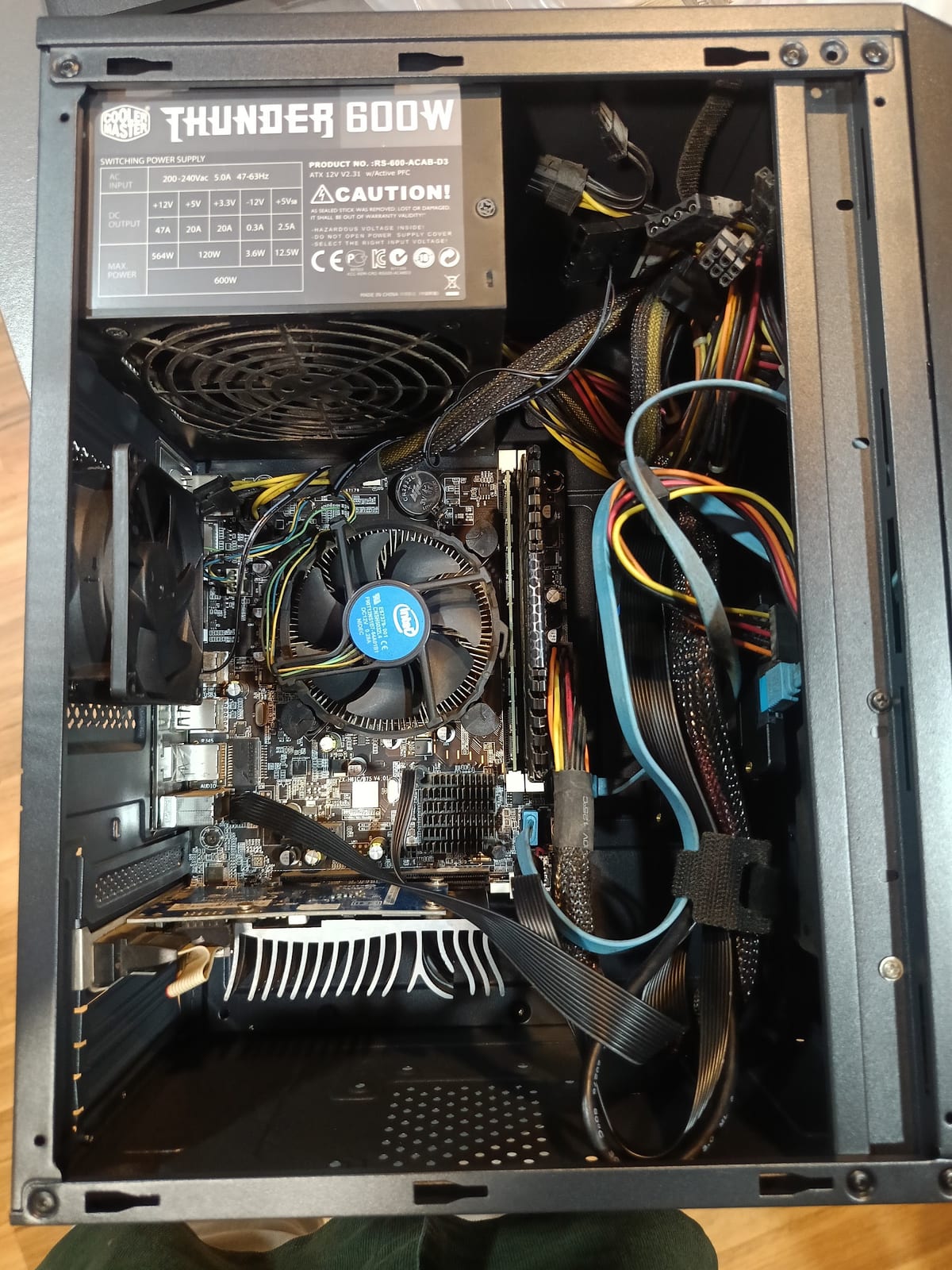 Open desktop case showing motherboard, cooling fan, power supply, graphics card and cables