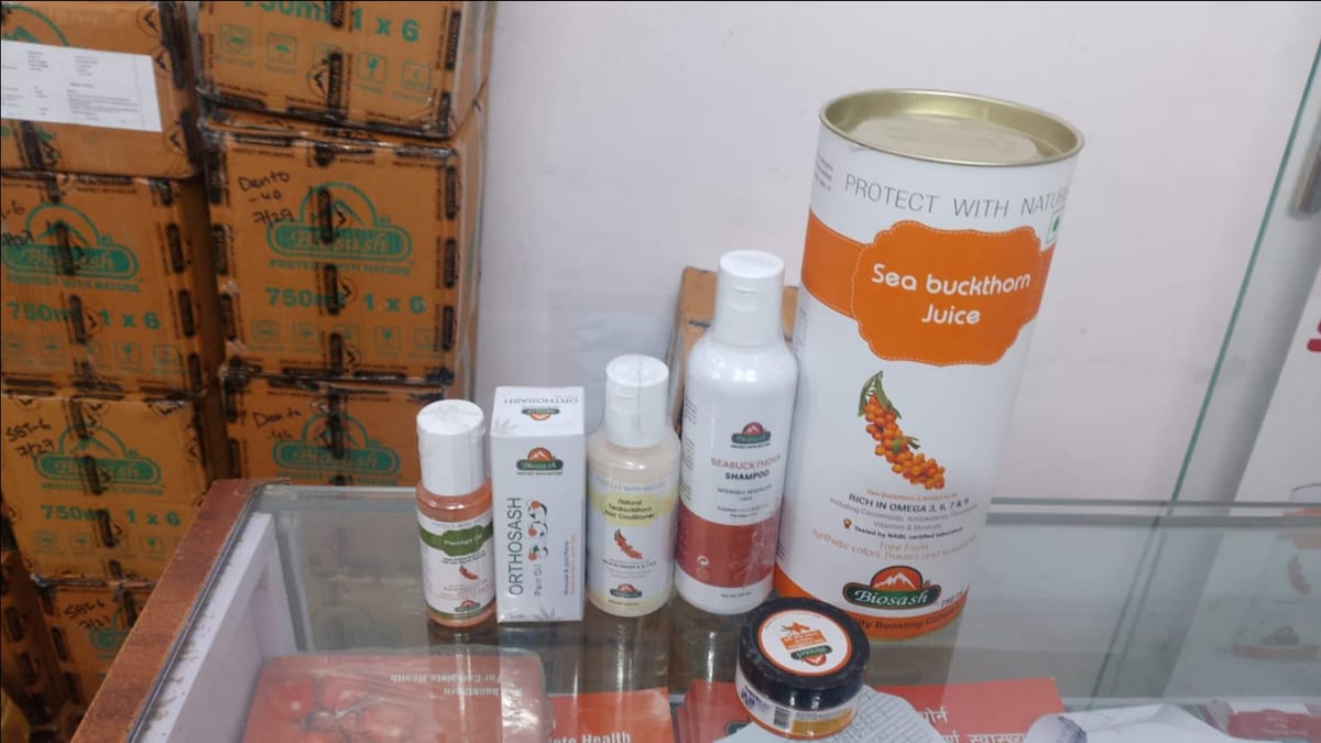 Bottles, jars and a large can of sea buckthorn juice in a glass case