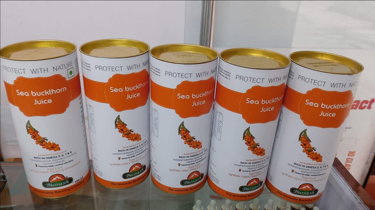 Five cans of sea buckthorn juice arranged side by side on a shelf