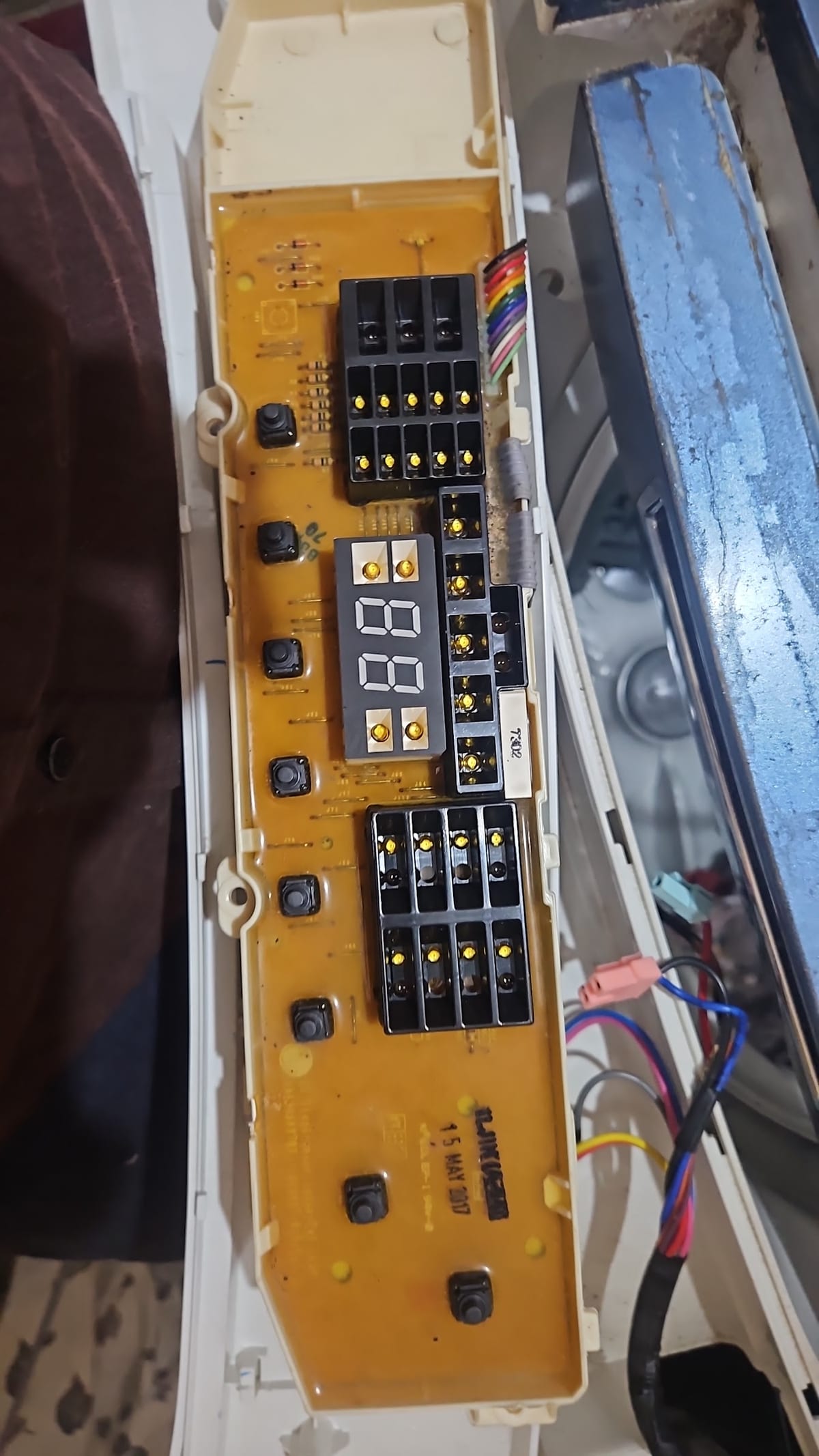 Close-up of an exposed orange electronic circuit board with wires and connectors