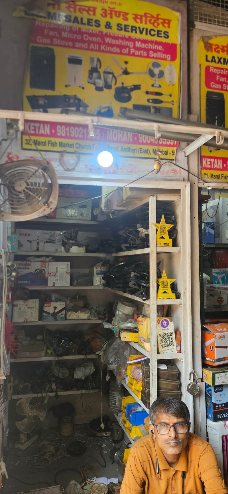 Laxmi Sales & Services shopfront with appliance repair signs and parts on display