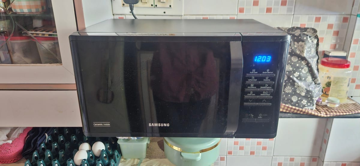 Black Samsung microwave on a tiled kitchen counter