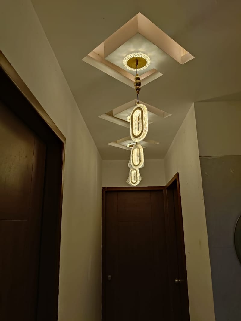 Narrow hallway with dark wooden doors and hanging ceiling lights