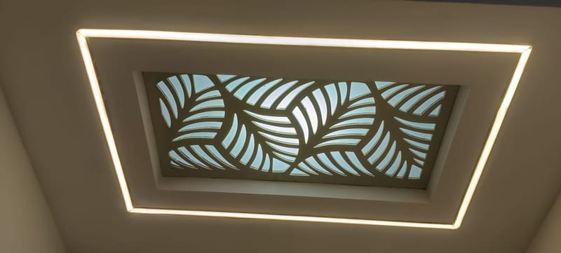 Recessed ceiling feature with illuminated trim and a leaf-patterned centre panel