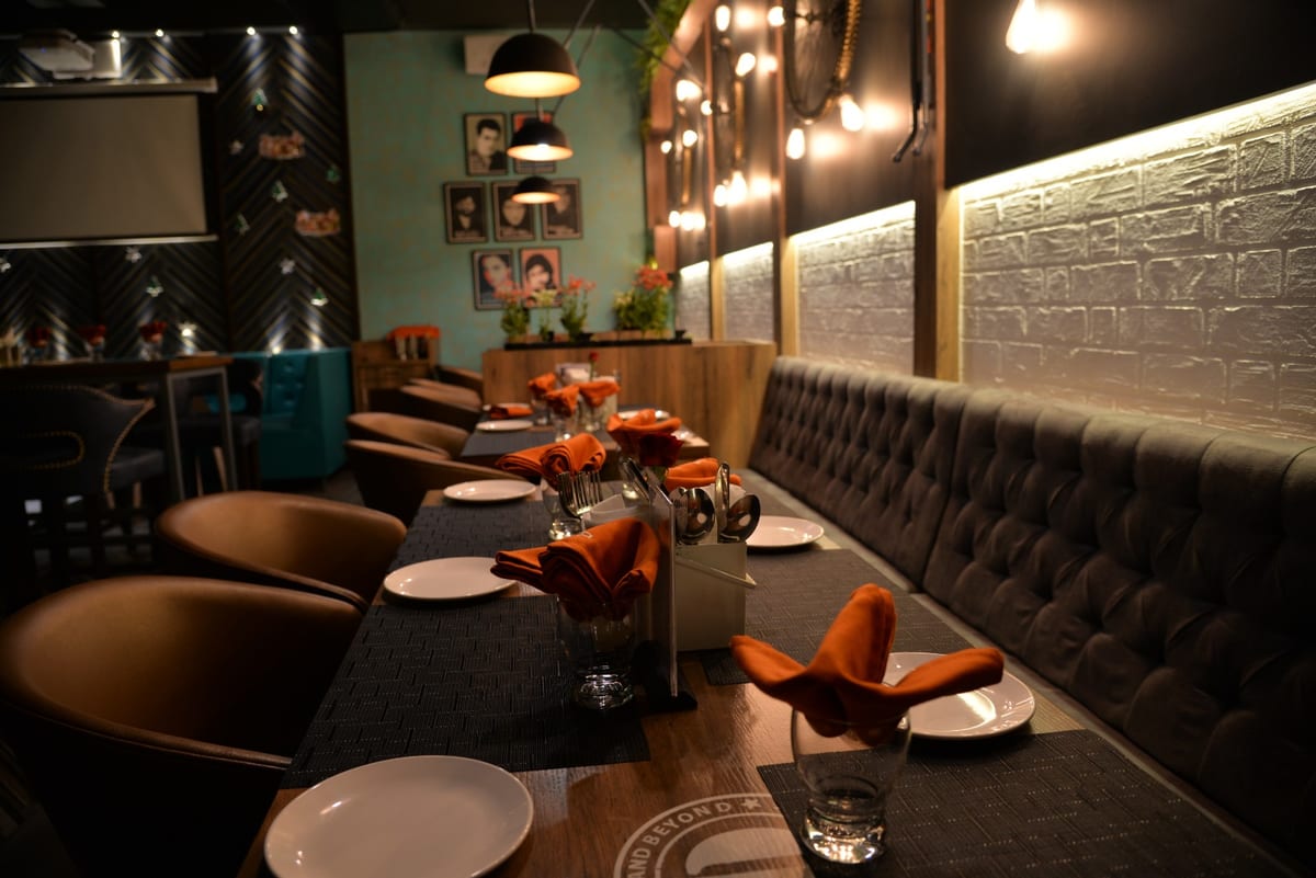 Hotel D-ADDA dining area with set tables, upholstered seating and pendant lights
