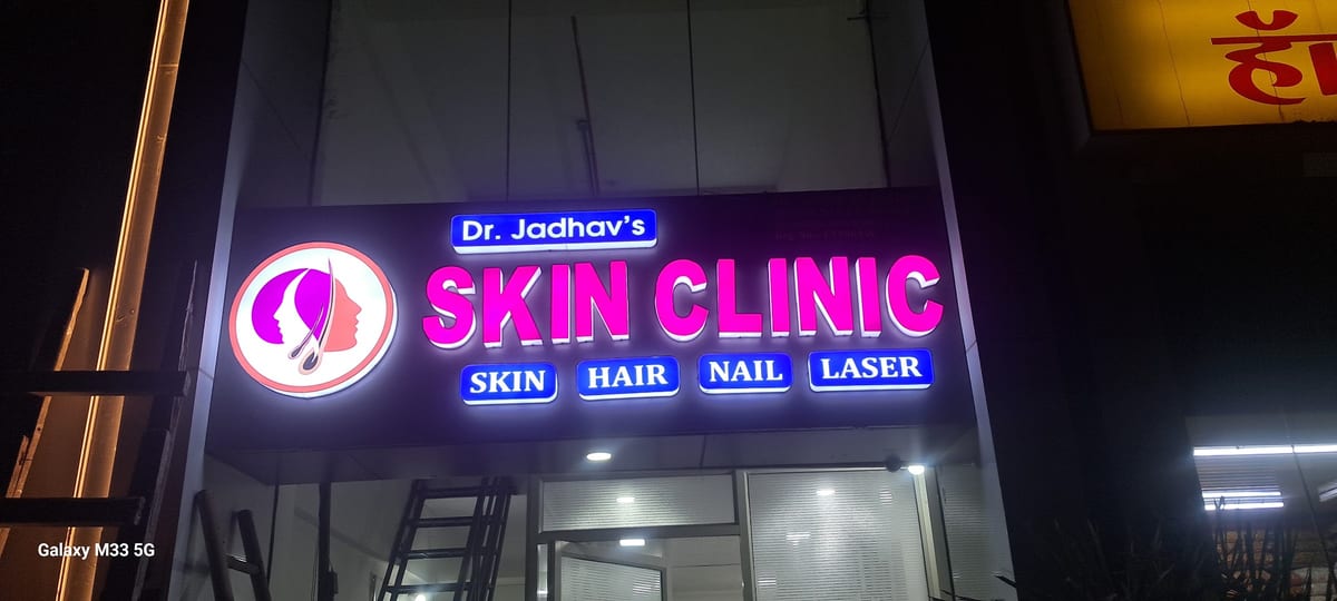 Illuminated Dr Jadhav's Skin Clinic sign on a building facade in Ravet
