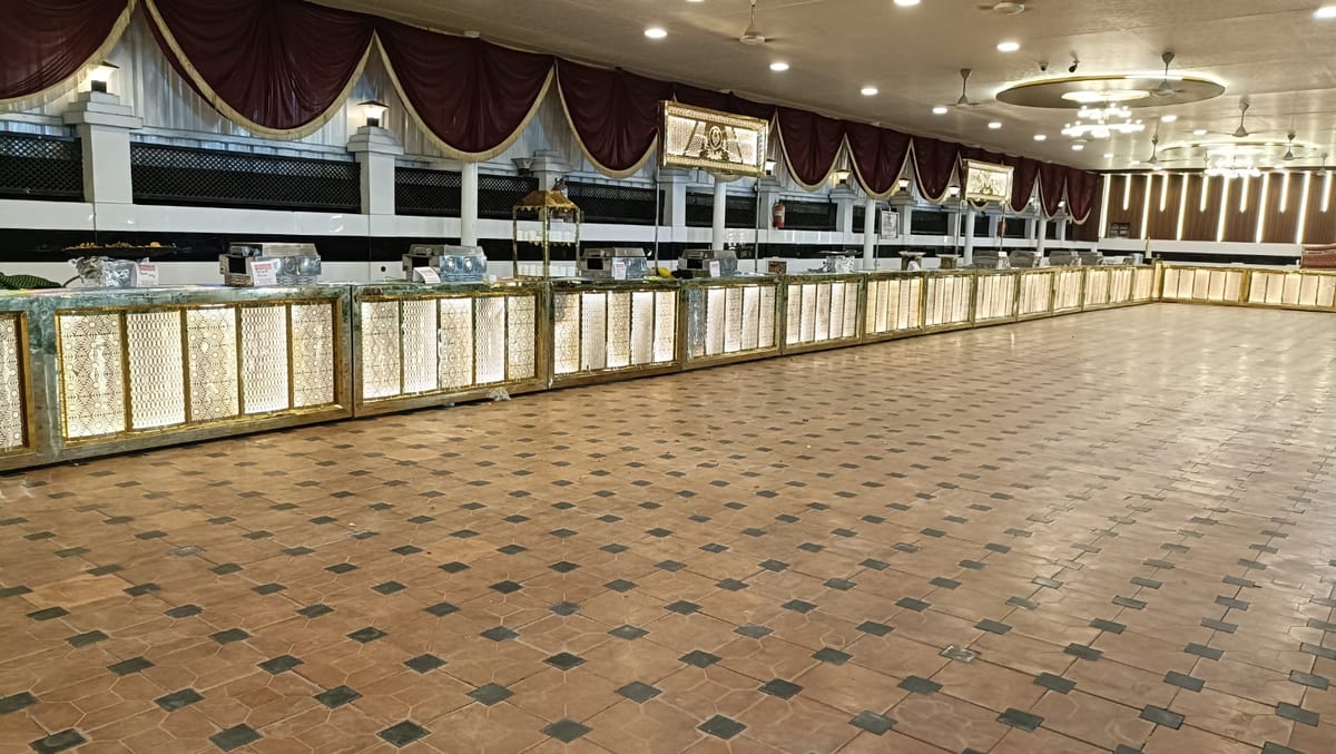 Large decorated hall with illuminated counters, chandeliers and burgundy drapes