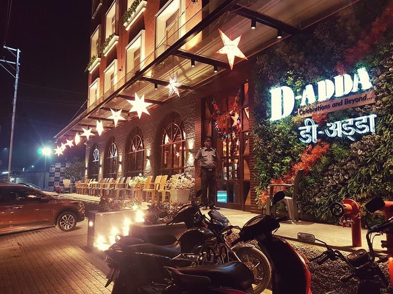 Illuminated D'ADDA storefront at night with star lights and outdoor seating in Badlapur