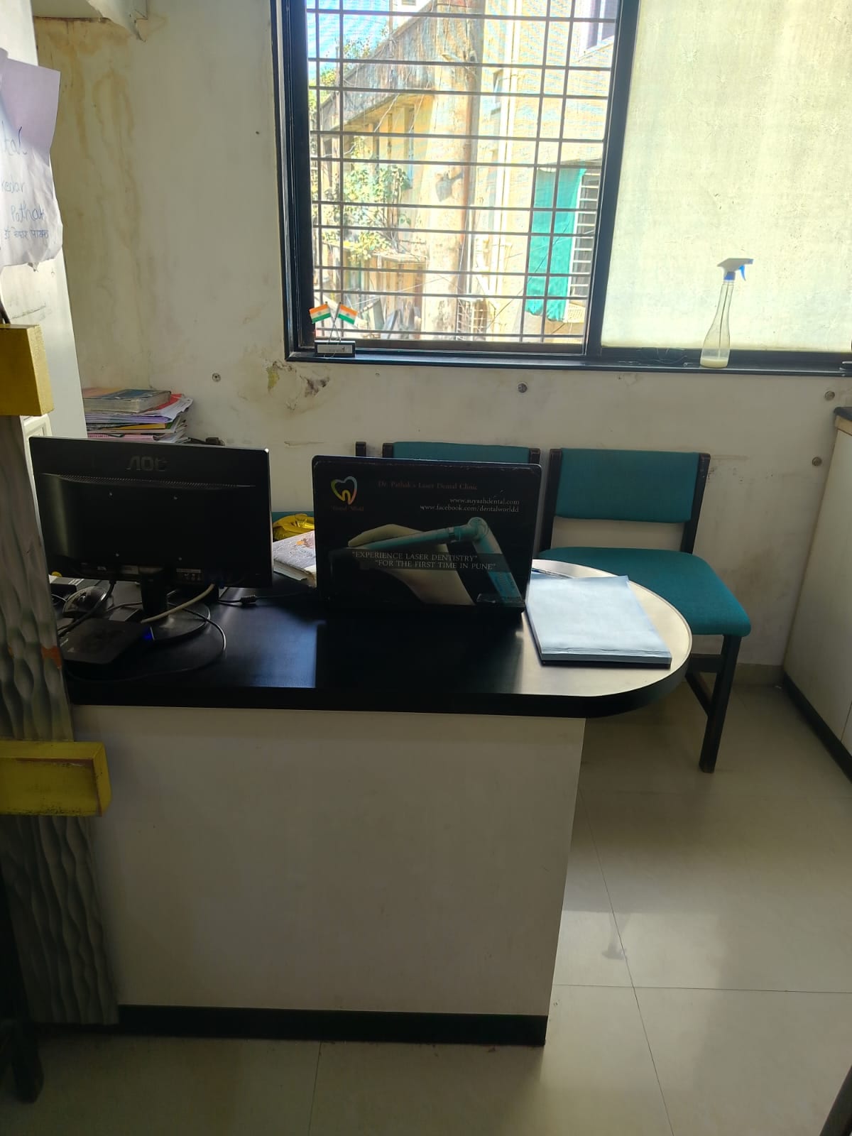 Reception desk with computer monitors, papers, chairs and a barred window