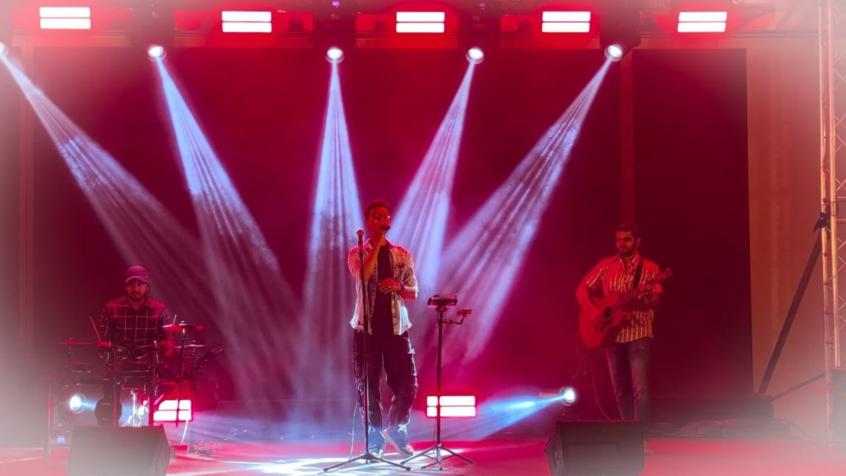 Live band performing on a stage under red and white lights at a Lonavala event