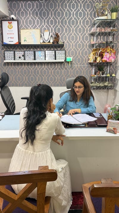 Astrologer assisting a client with paperwork at a desk in the office
