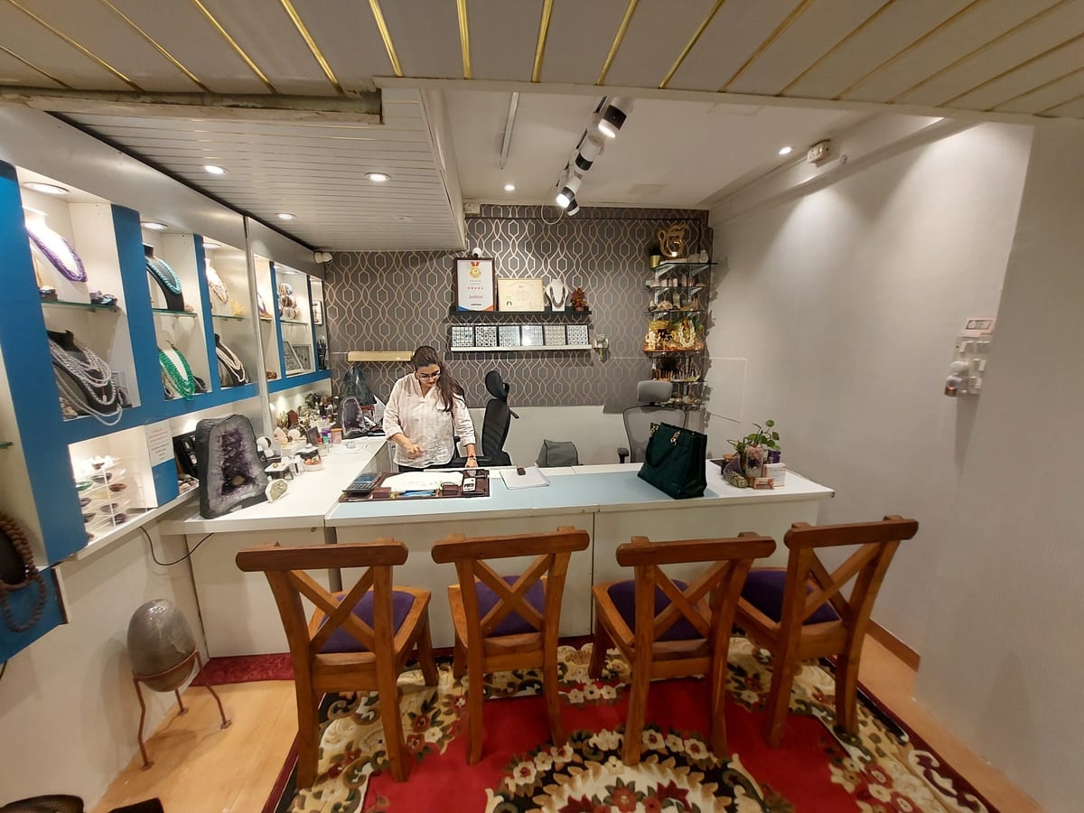 Jewellery shop interior with display cases, counter, seating and a person at the desk