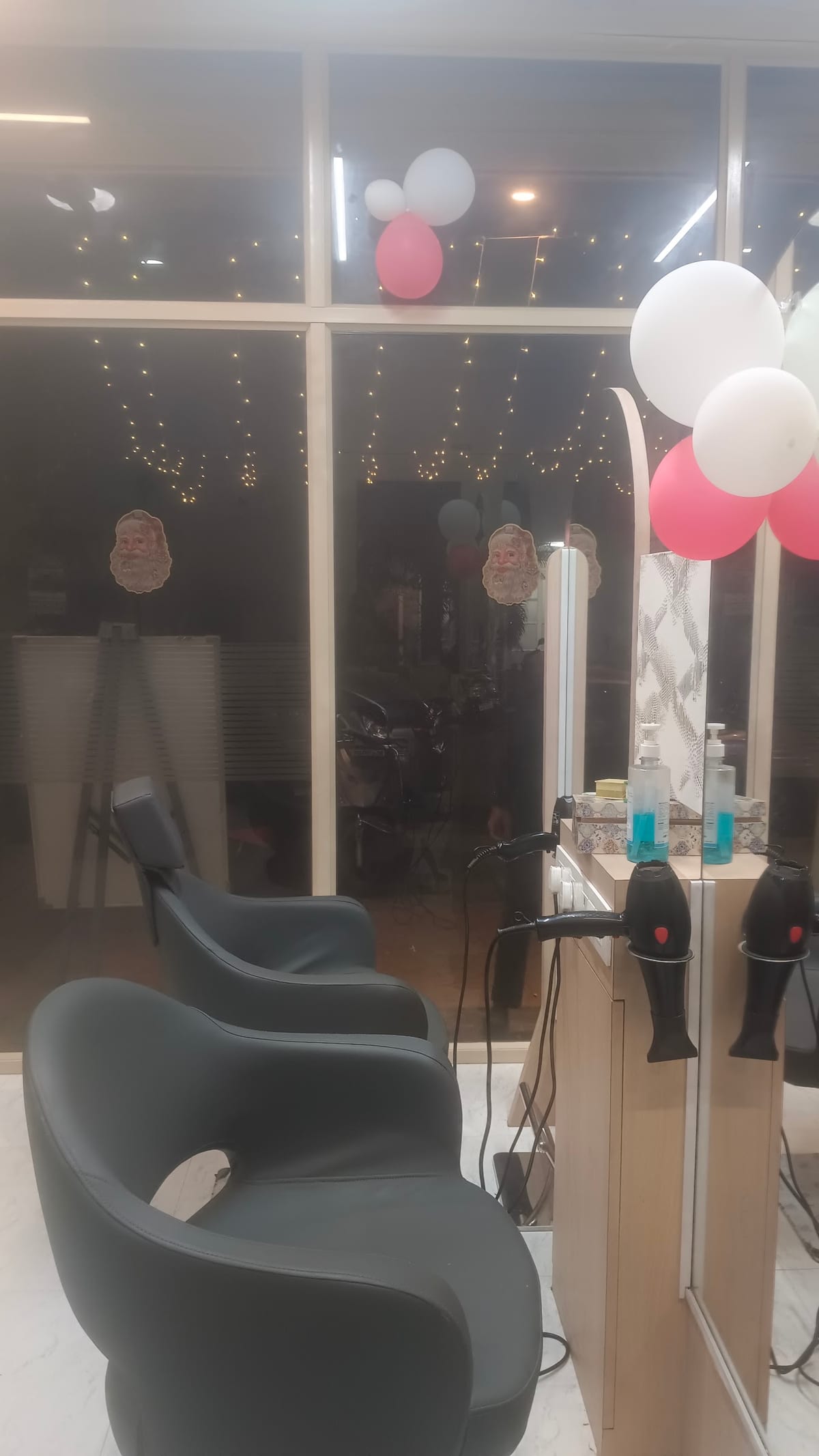 Salon interior with styling chair, mirrored wall, hair tools and balloon decorations