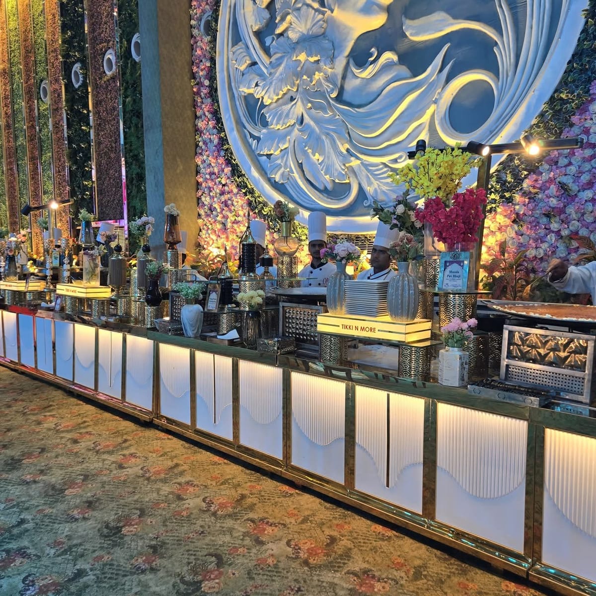 Staff serving at a decorated beverage counter with floral arrangements