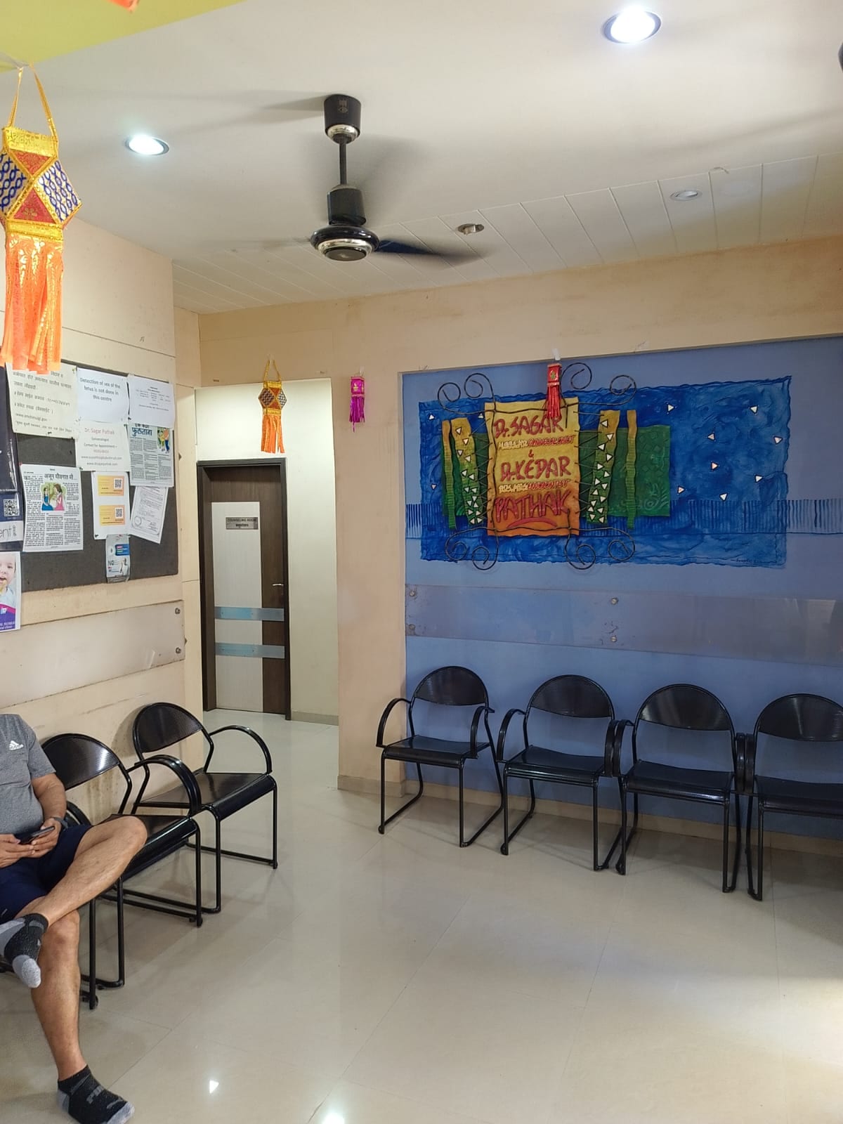 Waiting area with rows of chairs, wall notices and colorful wall artwork