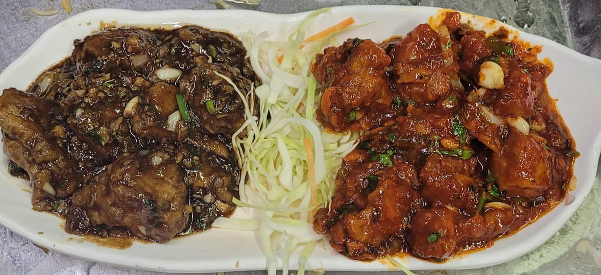 Divided plate of dark grilled meat and red-sauced meat with shredded cabbage