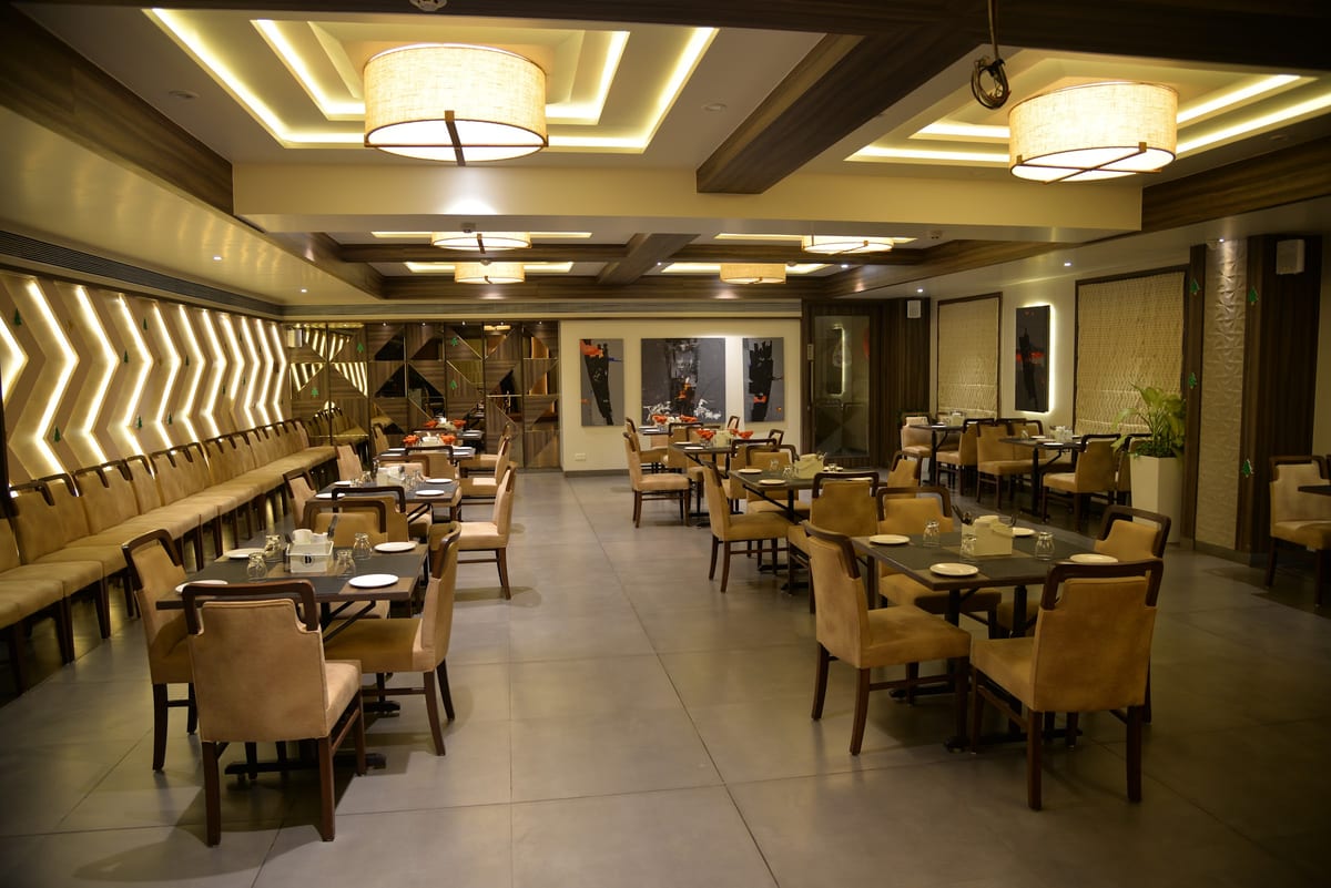 Dining room with tables, upholstered chairs and pendant lights