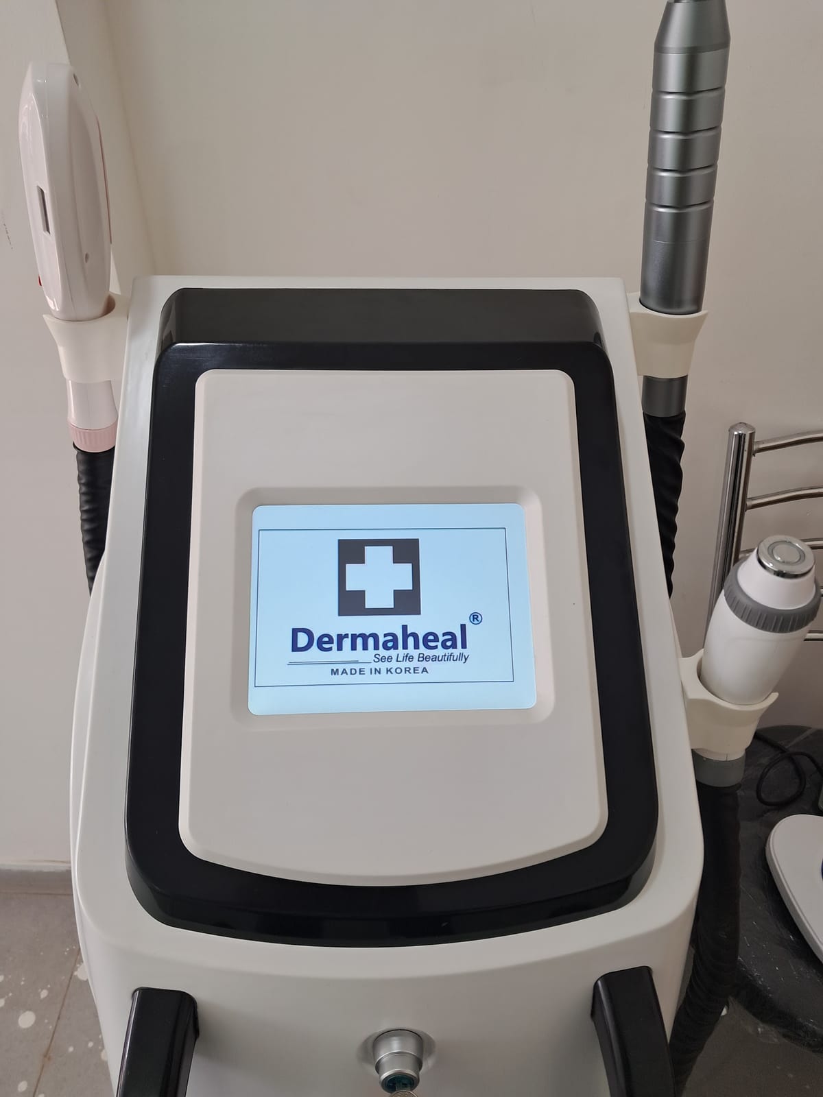 Dermaheal treatment device with lit display and attached handheld instruments