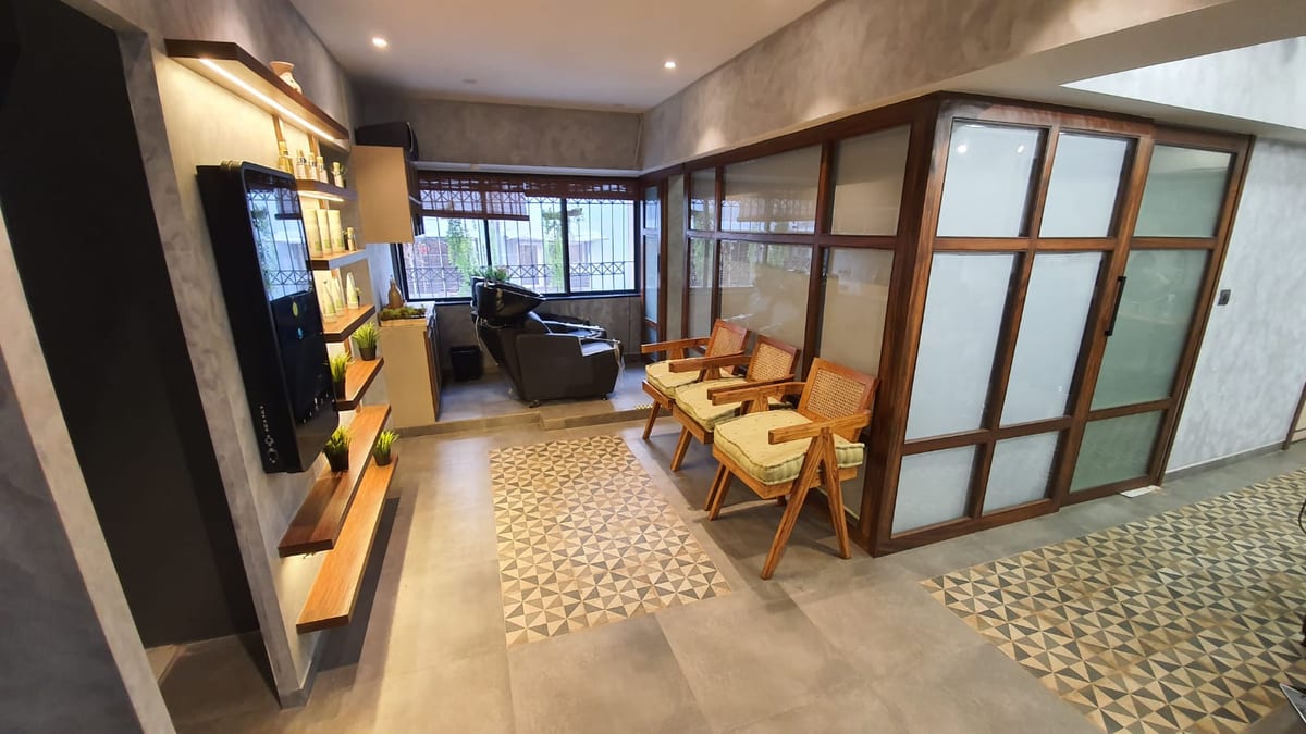Seating area with wooden chairs, shelving, frosted glass partitions and tiled floor