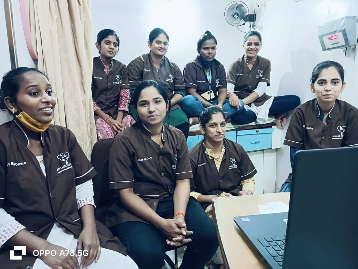 Staff in matching brown uniforms gathered together inside a room