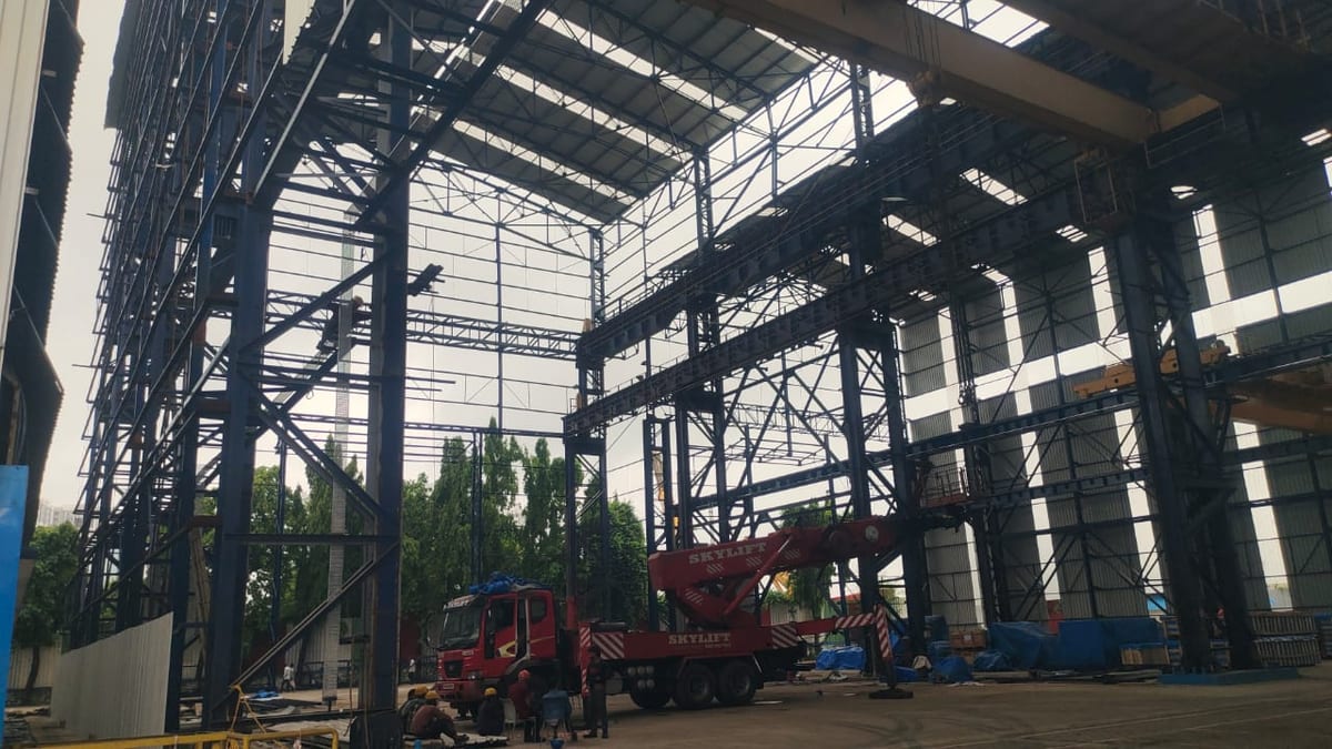Industrial warehouse interior with steel framework and a red crane truck
