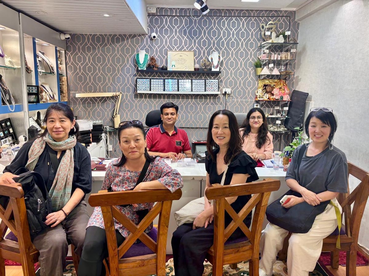 Five adults posing inside the shop beside jewellery displays and shelving
