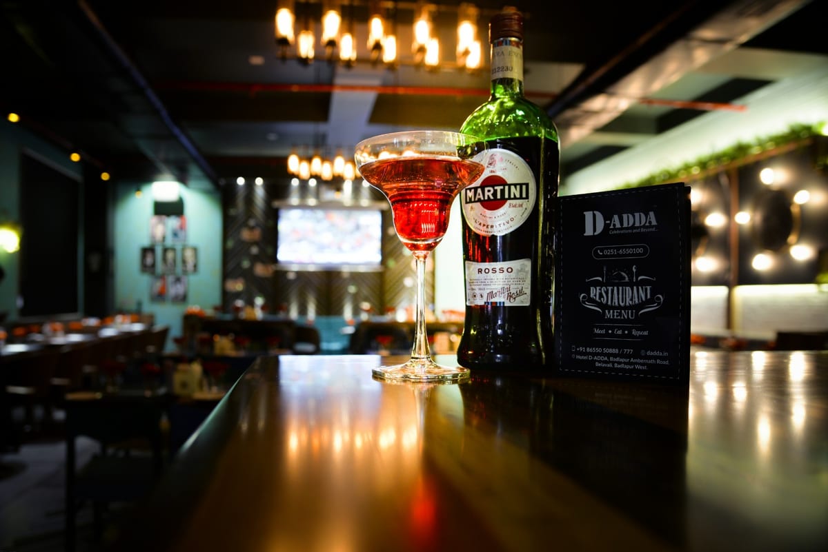 Martini Rosso bottle and a red cocktail on a restaurant table