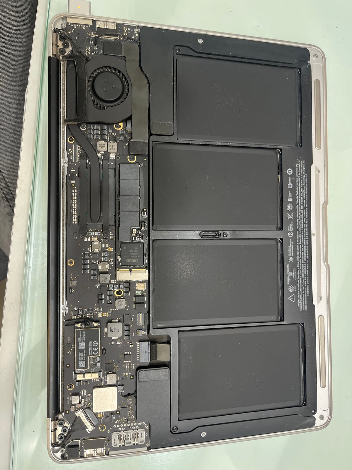 Open laptop with exposed circuit board, cooling fan and battery cells