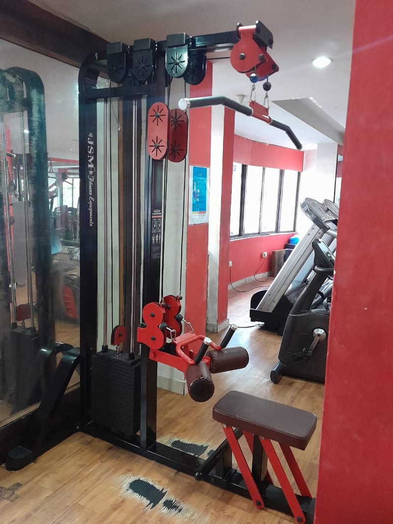Cable machine and exercise equipment beside windows inside the gym