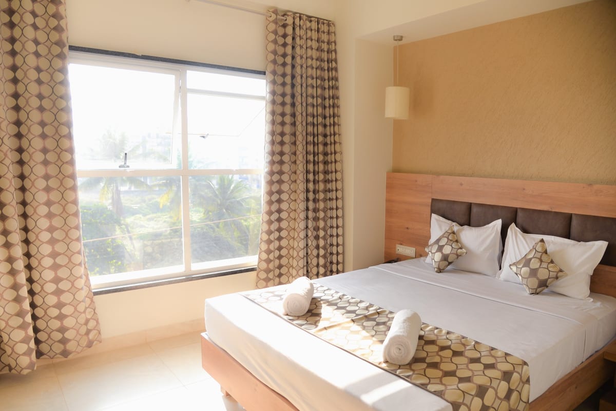 Relax Residency bedroom with a double bed, patterned runner and large window