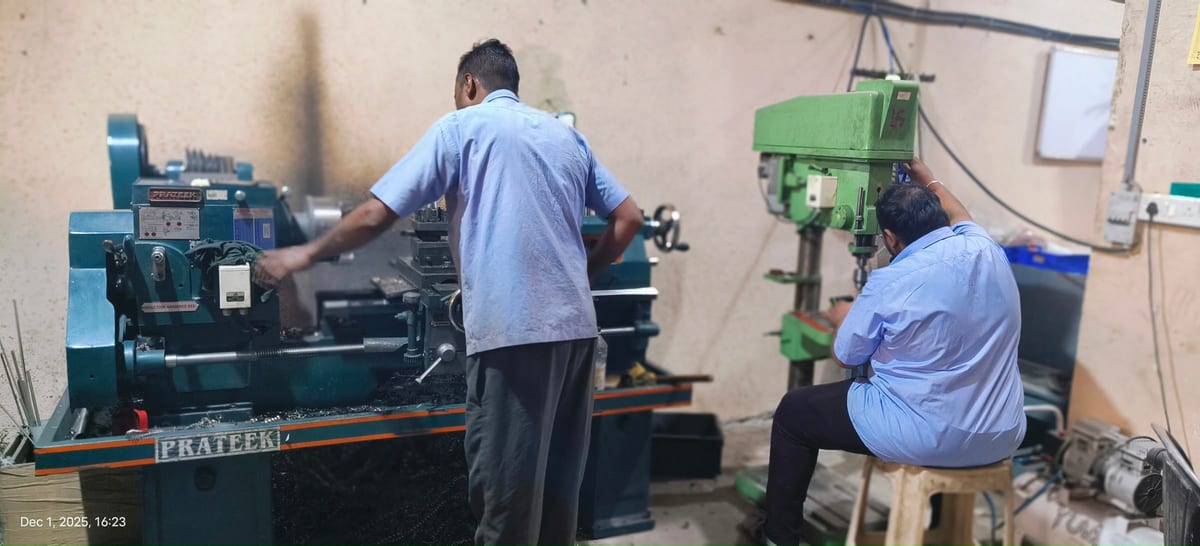 Two workers operating metalworking machinery in the workshop