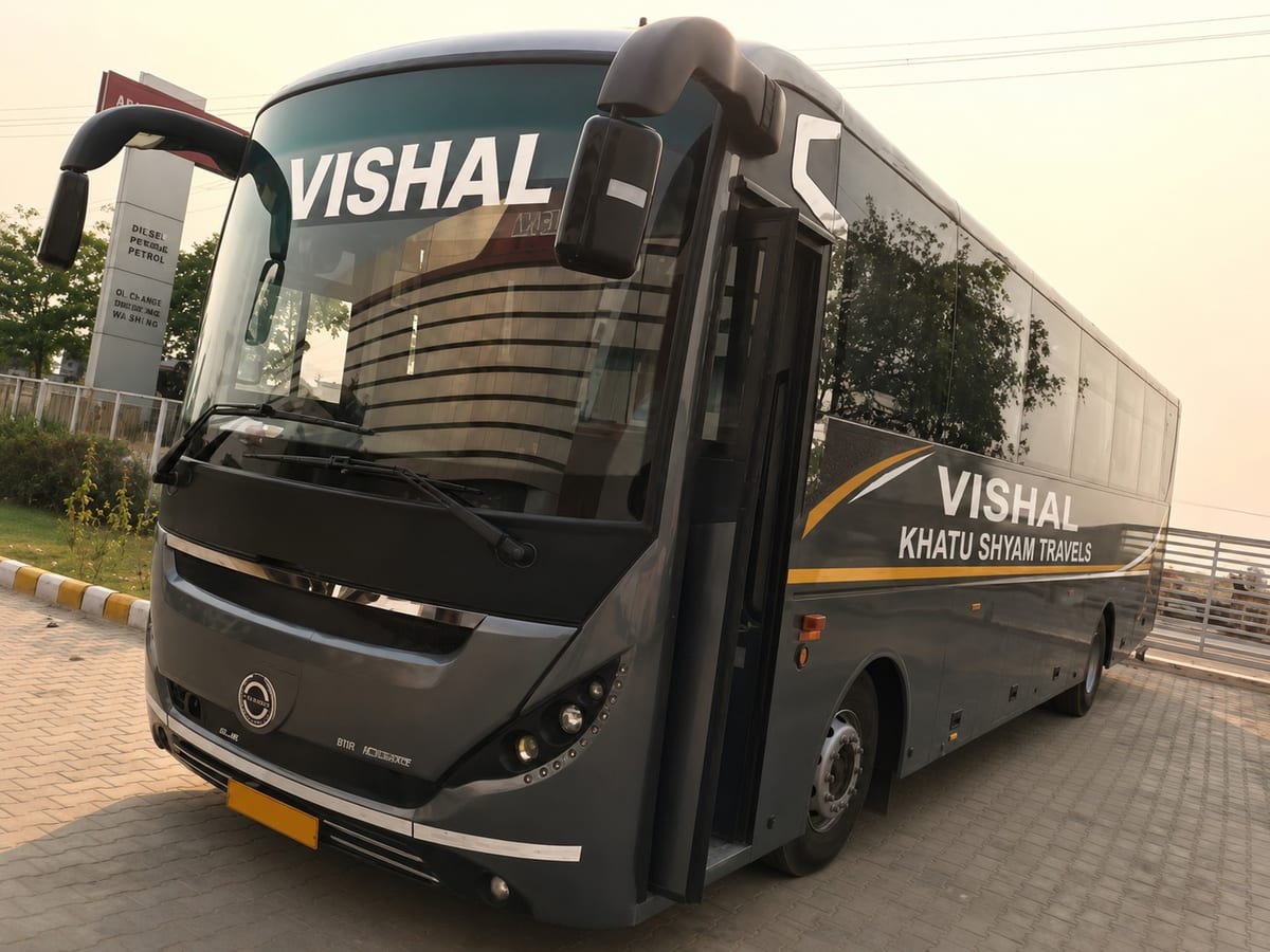 Black Vishal Khatu Shyam Travels coach parked on a paved area