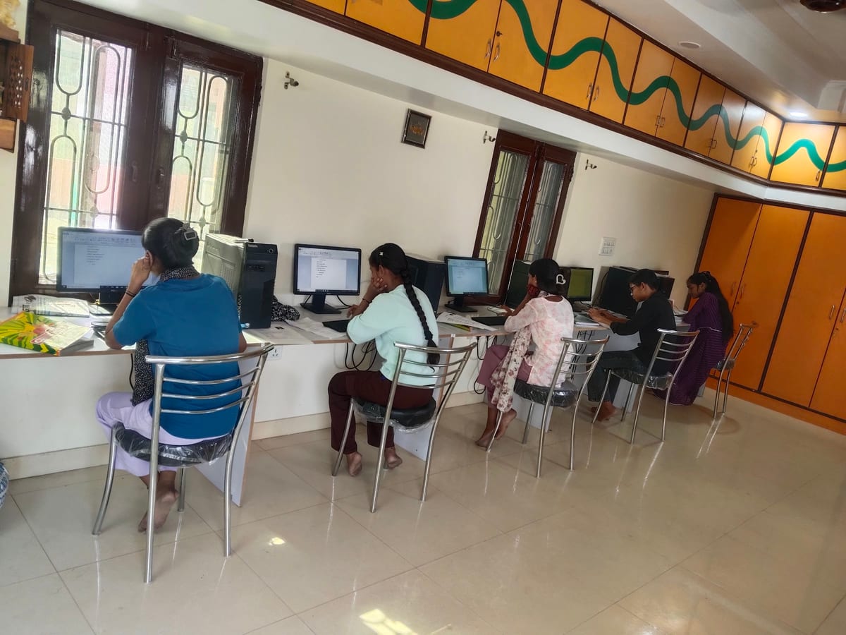 People seated at computers along a counter inside the lab