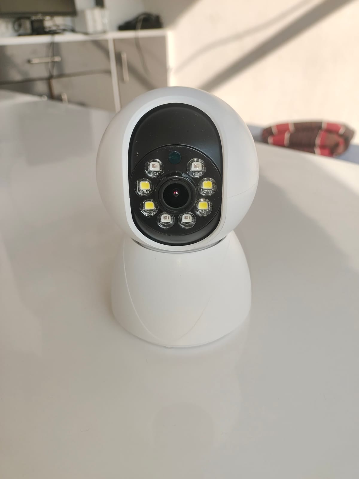 White indoor security camera on a light tabletop