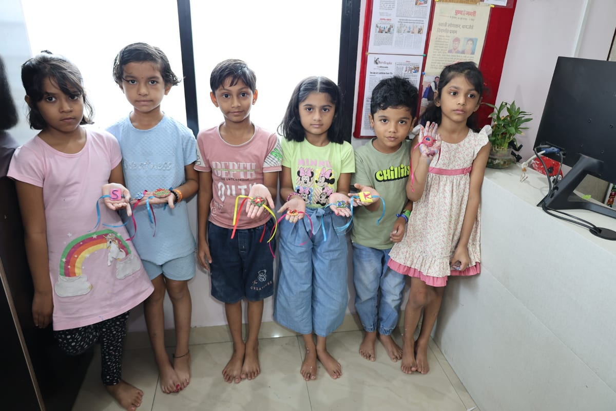Six children holding colourful handmade craft items indoors